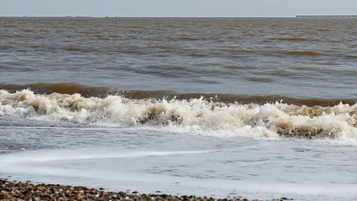 Brown Ocean Waves Crashing On Pebble Beach