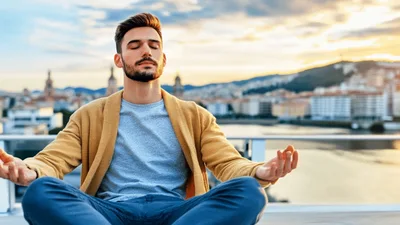Young Man Meditating On A Rooftop At Sunset