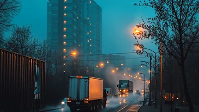 Trucks Driving on Wet City Road at Dusk