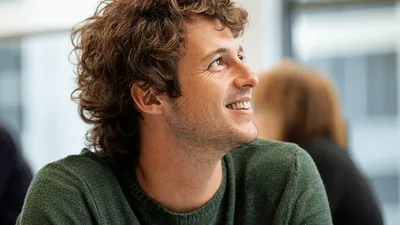 Young Man Smiling While Listening During A Business Meeting