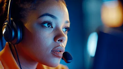 Young Woman Wearing Headset Working In Dark Office