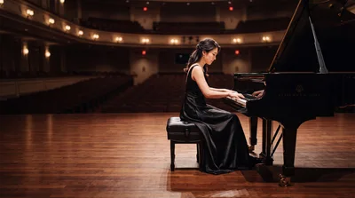 Pianist Performing On Grand Piano In Concert Hall