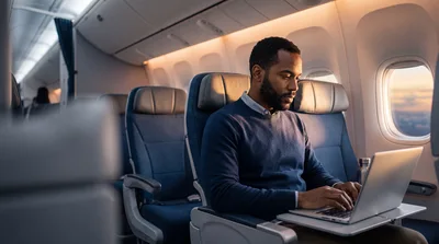 Man Working on Laptop During Airplane Flight
