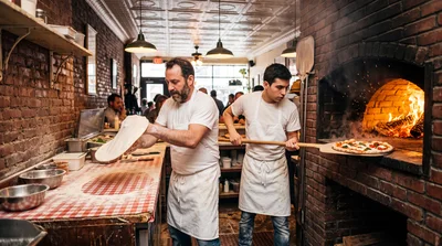 Professional Pizza Chefs Preparing Fresh Pies In Restaurant Kitchen
