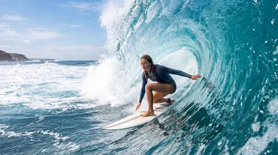 Young Female Surfer Riding A Large Ocean Wave