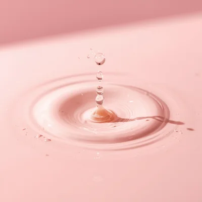 Pink Liquid Drop Creating Concentric Ripples