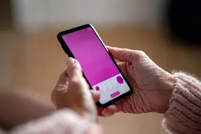Senior Woman Using Smartphone With Pink Screen