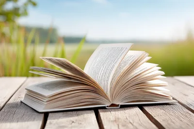 Open Book Resting On A Wooden Deck Outdoors