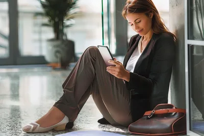 Businesswoman Sitting On Floor Using Digital Tablet