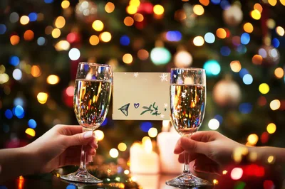 Two People Toasting With Champagne Glasses At Christmas