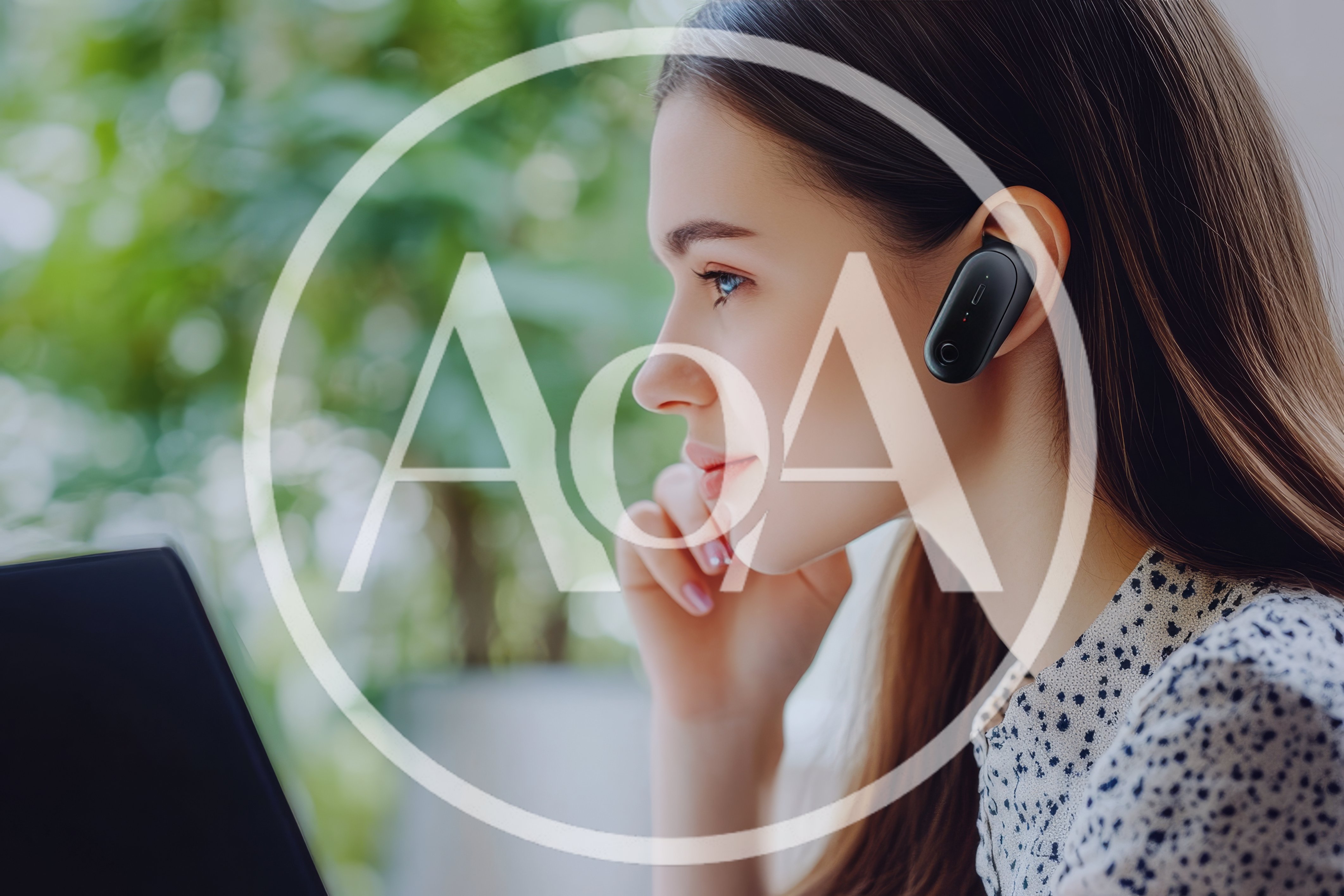 Young Woman Wearing Bluetooth Earpiece Working On Laptop