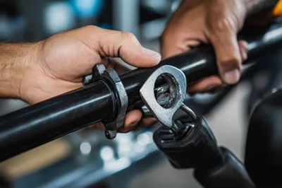 Mechanic Assembling Metal Components On A Black Bar