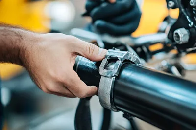 Mechanic Adjusting Metal Clamp On Industrial Pipe