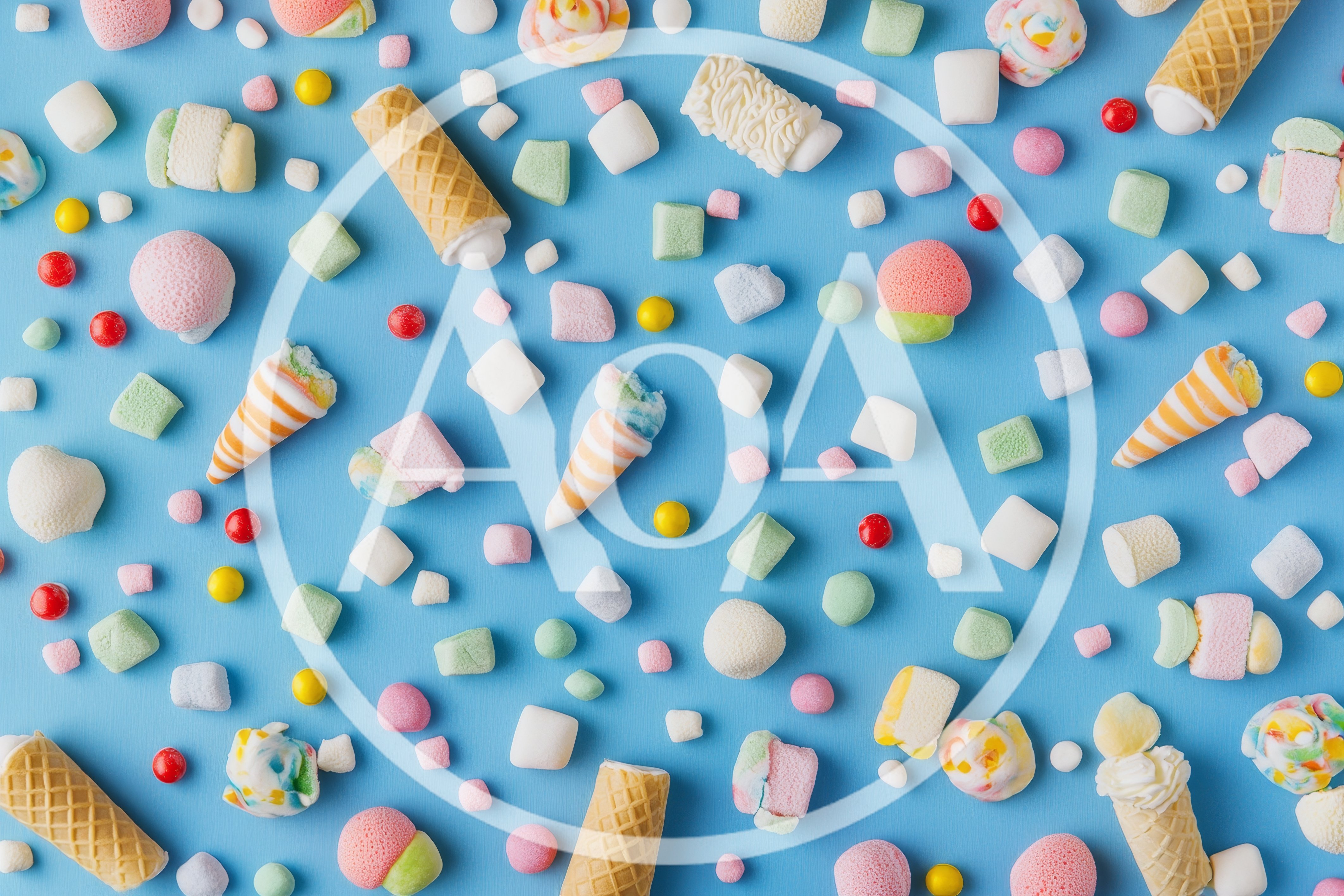 Assorted Marshmallow Candies and Waffle Cones on Blue Background