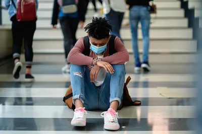 Sad Student Sitting Alone On School Hallway Floor