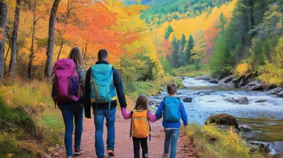 Family Hiking Along A River In Autumn