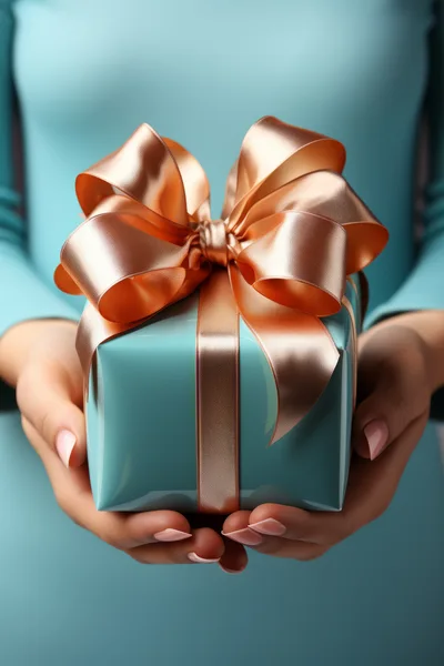 Woman Holding A Turquoise Gift Box With Gold Ribbon