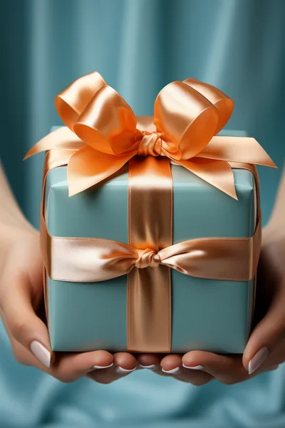 Hands Holding A Gift Box With A Satin Ribbon