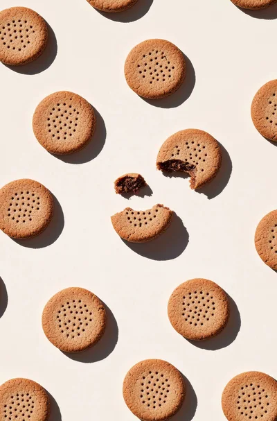 Pattern of Chocolate Sandwich Cookies on Beige Background