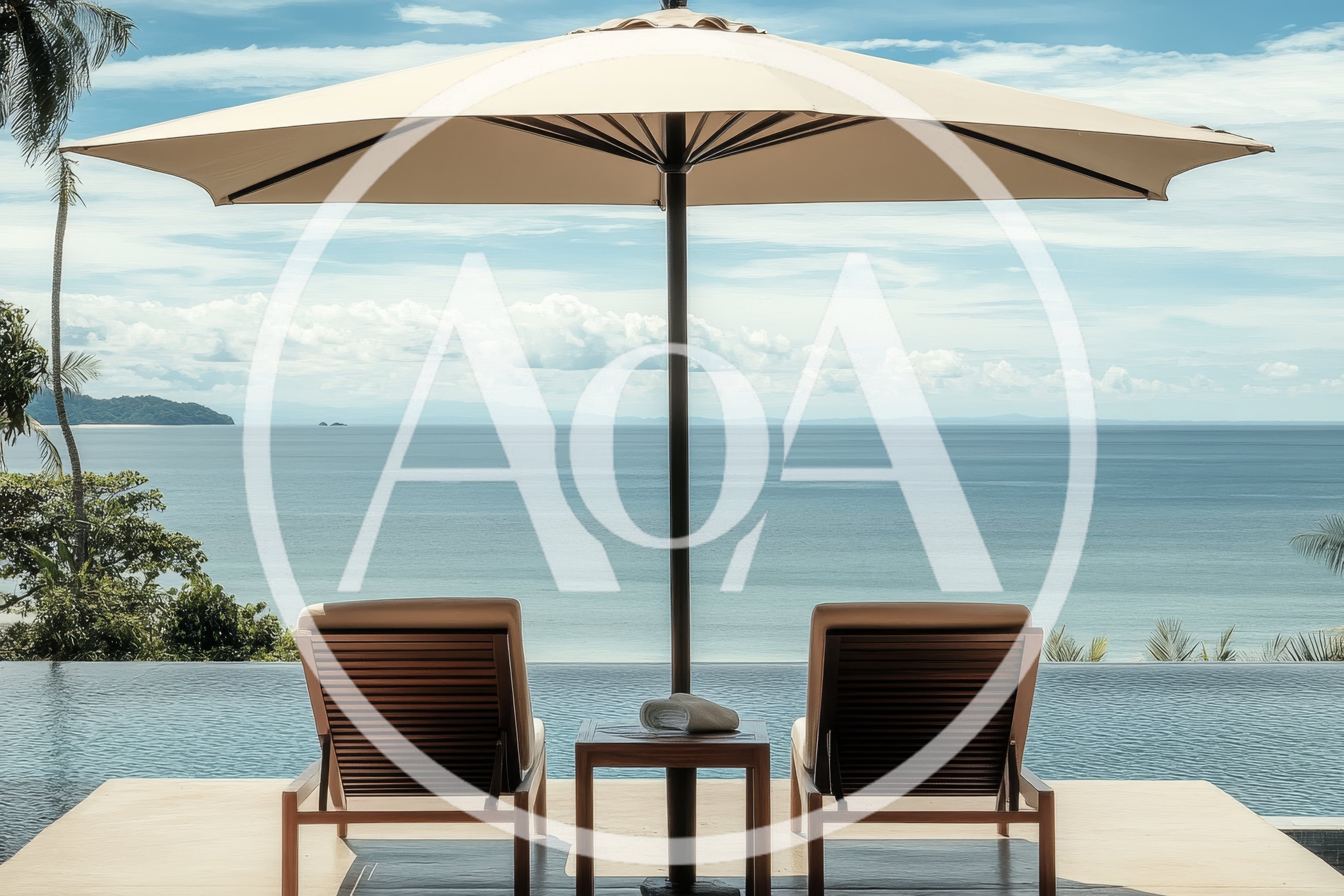 Two Lounge Chairs Under Umbrella Overlooking Tropical Ocean