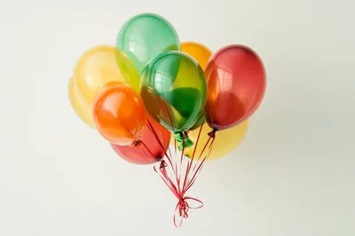 Bunch Of Colorful Balloons Floating Against White Background