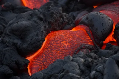 Molten Lava Flowing Through Cooled Volcanic Rock