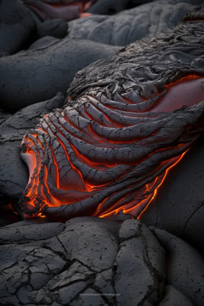 Molten Lava Flowing Over Hardened Volcanic Rock