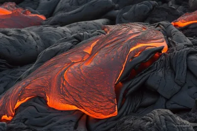 Molten Lava Flowing Over Hardened Volcanic Rock