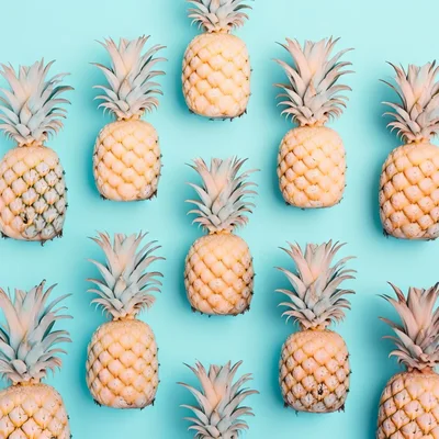 Pattern of Fresh Pineapples on Light Blue Background