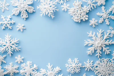 White Snowflake Ornaments Arranged on Light Blue Background
