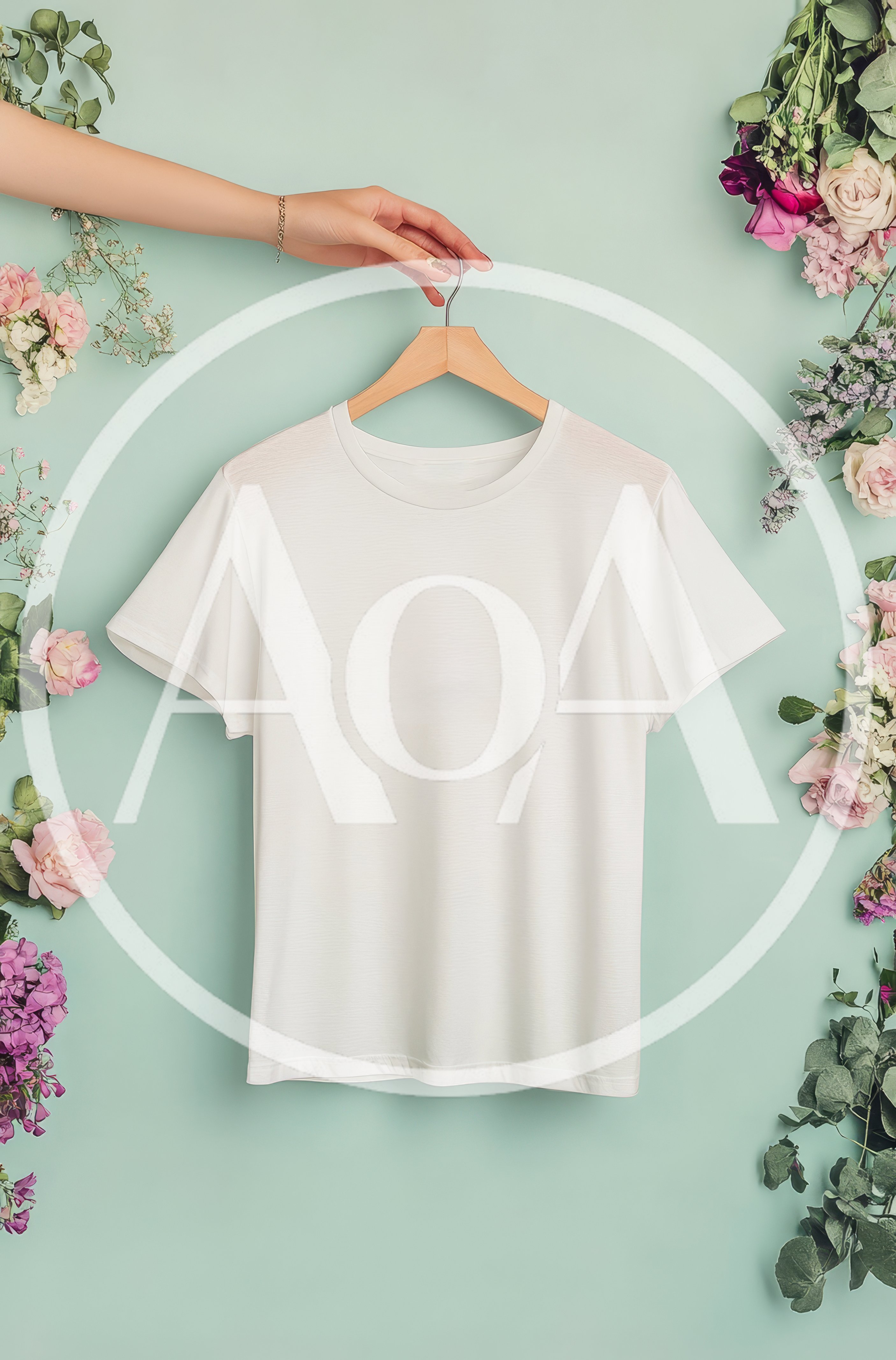 White T-Shirt Mockup Held By Hand With Floral Decor