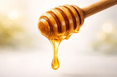 Honey Dripping From A Wooden Honey Dipper