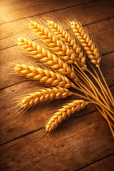 Golden Wheat Stalks Arranged On Rustic Wooden Surface