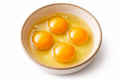 Four Raw Egg Yolks In A Ceramic Bowl