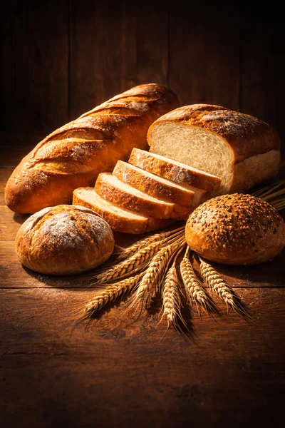 Assorted Freshly Baked Bread Loaves and Wheat Stalks