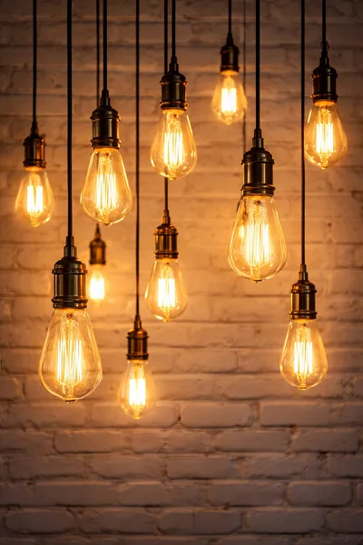 Vintage Edison Light Bulbs Hanging Against Brick Wall