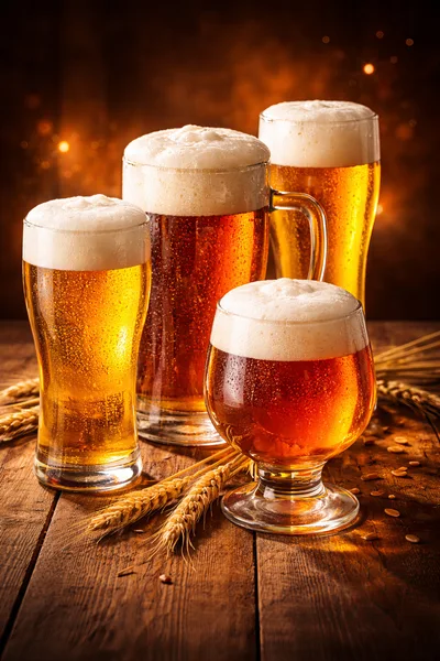 Four Glasses Of Assorted Craft Beer On Wooden Table