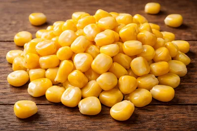 Fresh Yellow Sweet Corn Kernels on Wooden Table