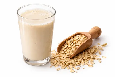 Glass Of Oat Milk With Rolled Oats In Wooden Scoop