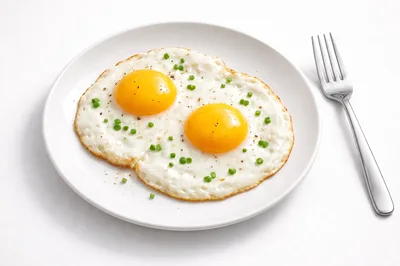 Two Sunny Side Up Eggs on a White Plate