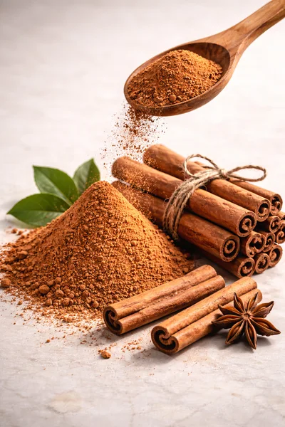 Cinnamon Powder Pouring From Wooden Spoon
