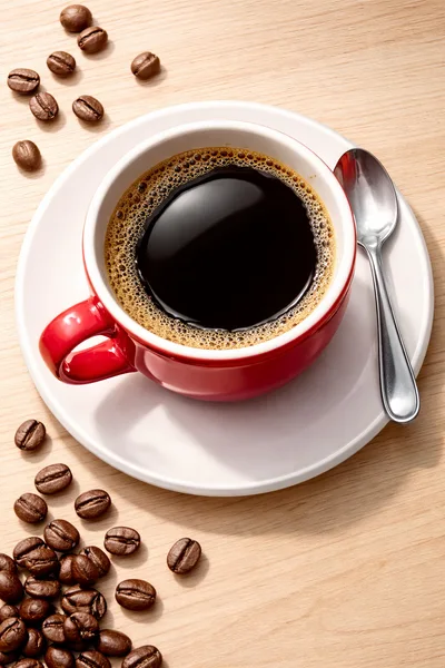 Red Coffee Cup With Coffee Beans On Wooden Table