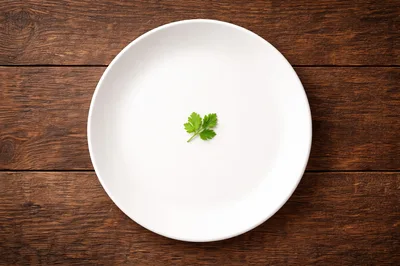 Single Parsley Sprig Centered on a White Plate