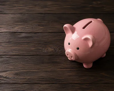Pink Piggy Bank On Dark Wooden Surface