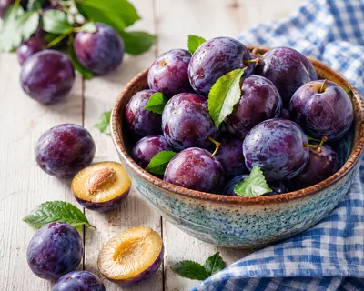 Fresh Ripe Plums In A Rustic Ceramic Bowl