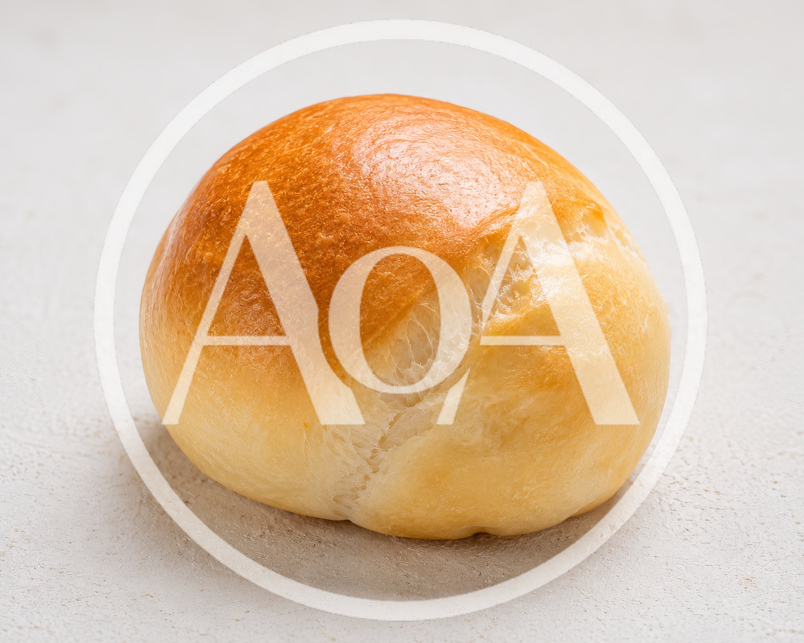 Single Golden Brown Dinner Roll on White Surface