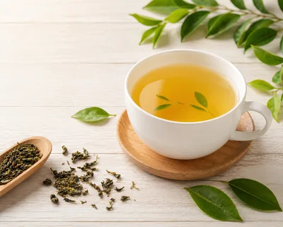 Cup Of Green Tea With Loose Leaves On Wooden Table