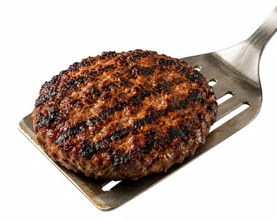 Grilled Beef Burger Patty On A Metal Spatula