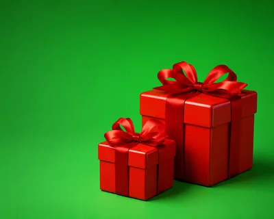 Two Red Gift Boxes With Ribbons On Green Background