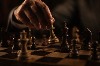 Hand Moving A Chess Piece On A Dark Board